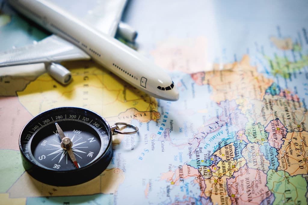 Selective Focus Of Miniature Tourist On Compass Over Map With Plastic Toy Airplane Abstract Background To Travel Concept