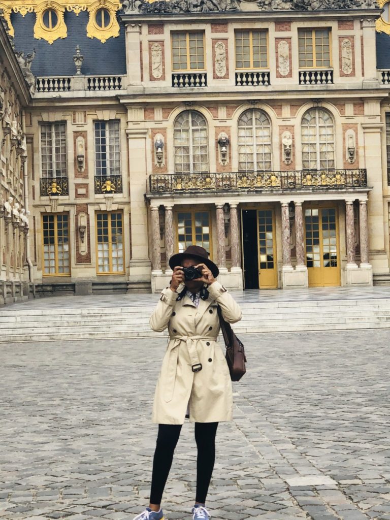 Black woman taking pictures at Palace of Versailles